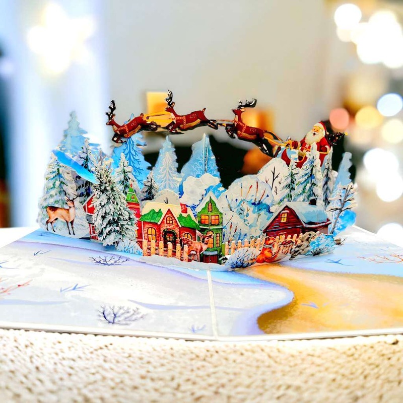 Snowy Village with Flying Santa on Sleigh & Reindeers Pop Card